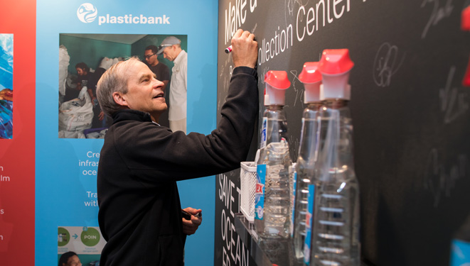 Fisk Johnson signing a promise wall to end ocean plastic at Greenbiz