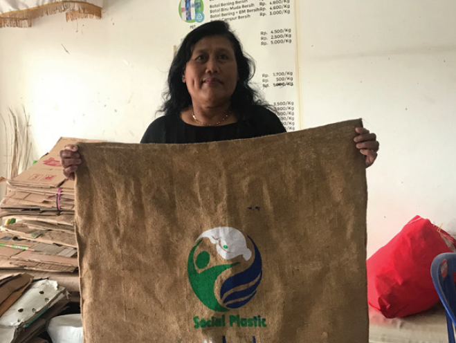 Women holding up Plastic Bank collectors bag.