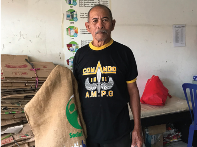 Man holding plastic bank recycling collectors bag.