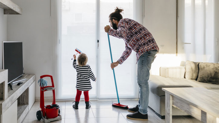 Young girl helping her father clean.