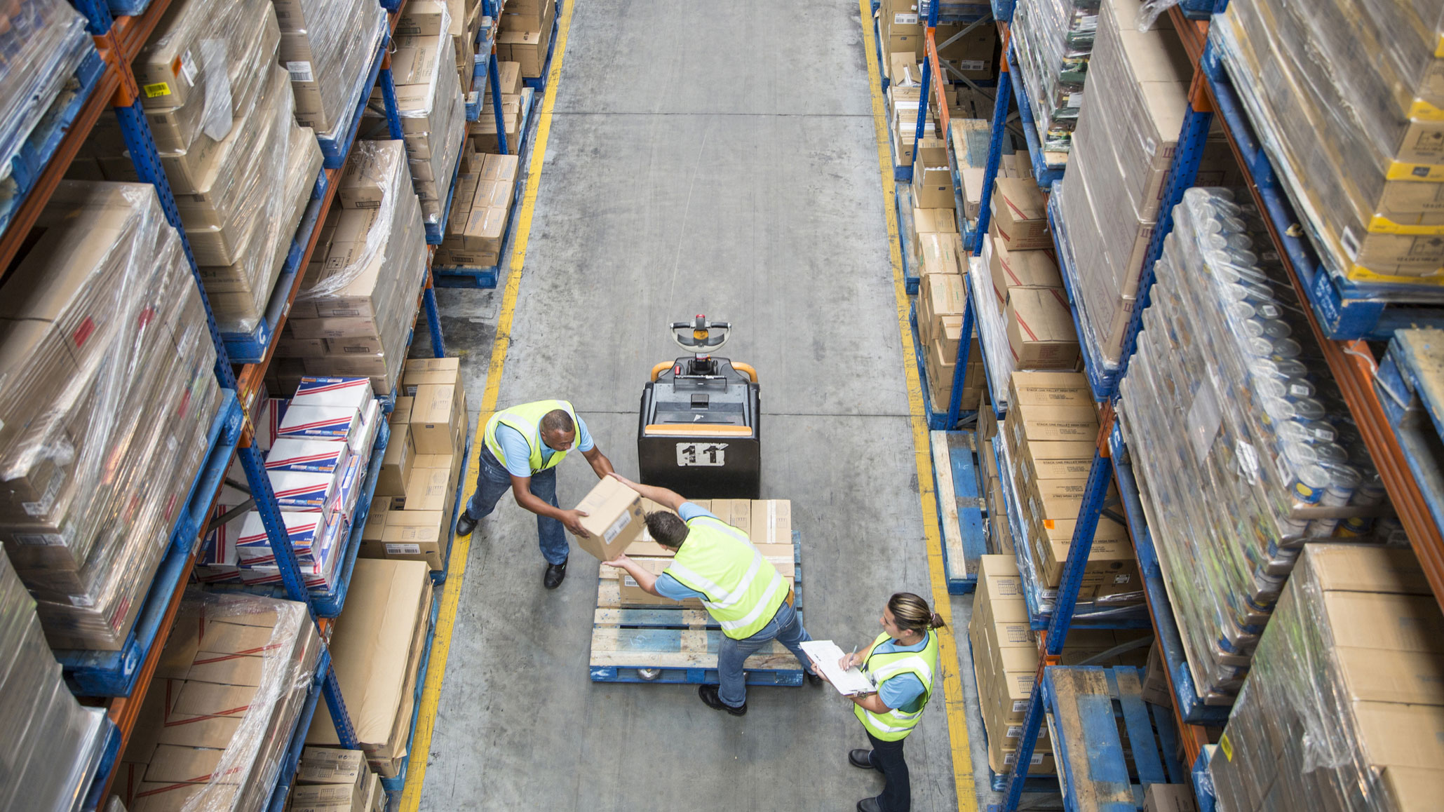 People filling a fork lift in a warehouse